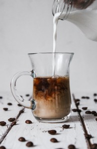 Mleko nalewane jest do kubka kawy